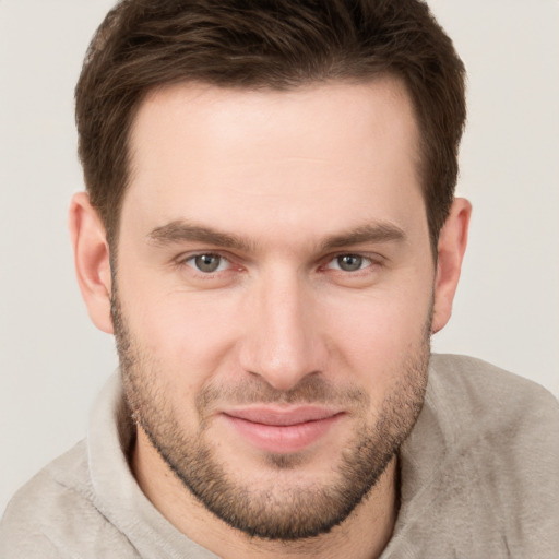 Joyful white young-adult male with short  brown hair and grey eyes