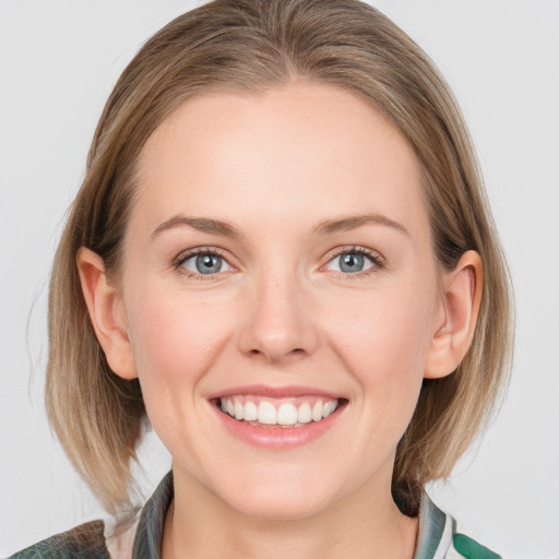 Joyful white young-adult female with medium  brown hair and blue eyes