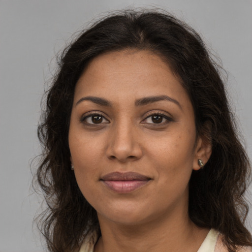 Joyful black young-adult female with long  brown hair and brown eyes