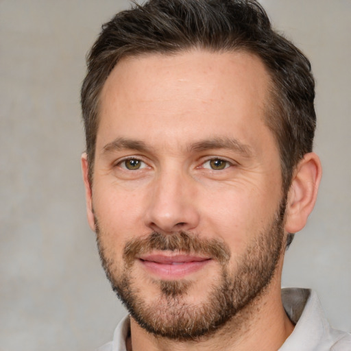 Joyful white adult male with short  brown hair and brown eyes