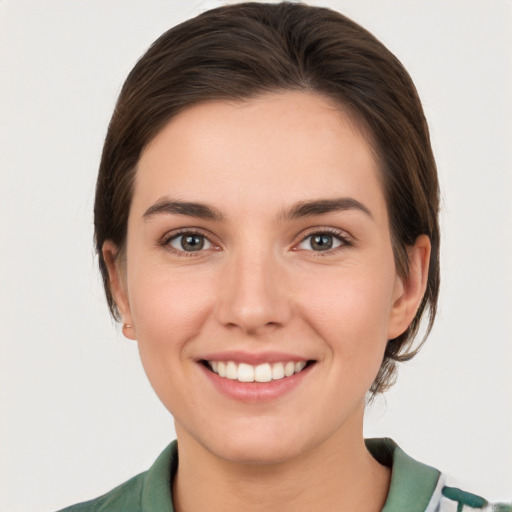 Joyful white young-adult female with medium  brown hair and green eyes