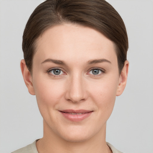 Joyful white young-adult female with short  brown hair and grey eyes