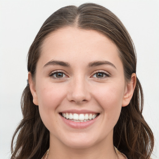 Joyful white young-adult female with long  brown hair and grey eyes