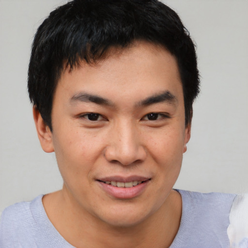 Joyful asian young-adult male with short  brown hair and brown eyes