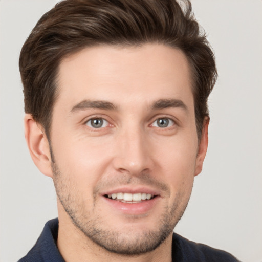 Joyful white young-adult male with short  brown hair and grey eyes