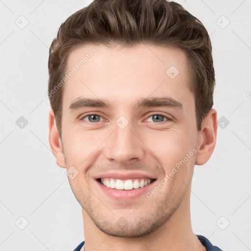 Joyful white young-adult male with short  brown hair and grey eyes