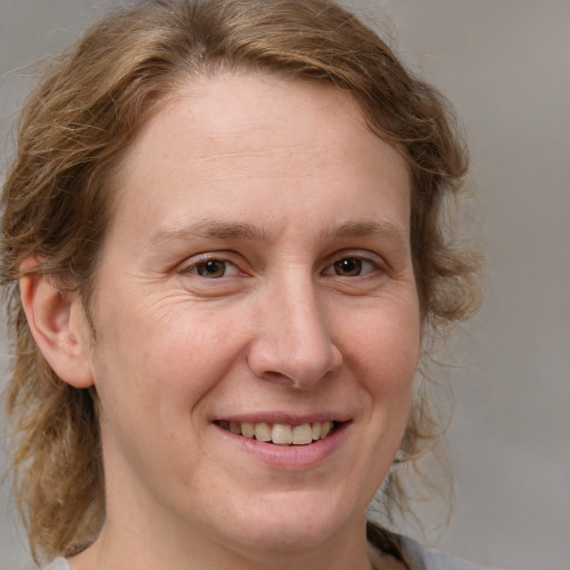 Joyful white adult female with medium  brown hair and blue eyes