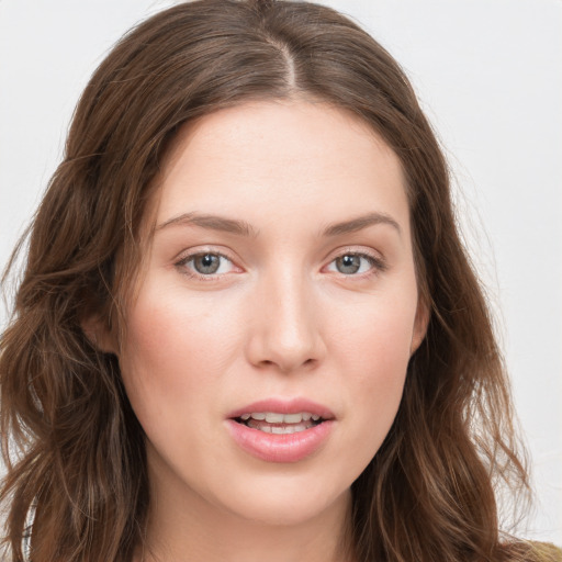 Joyful white young-adult female with long  brown hair and blue eyes