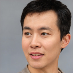 Joyful asian young-adult male with short  black hair and brown eyes