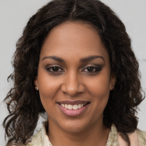 Joyful black young-adult female with long  brown hair and brown eyes