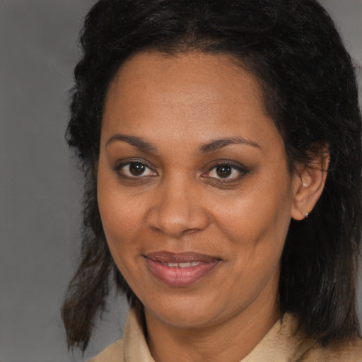 Joyful black adult female with medium  brown hair and brown eyes