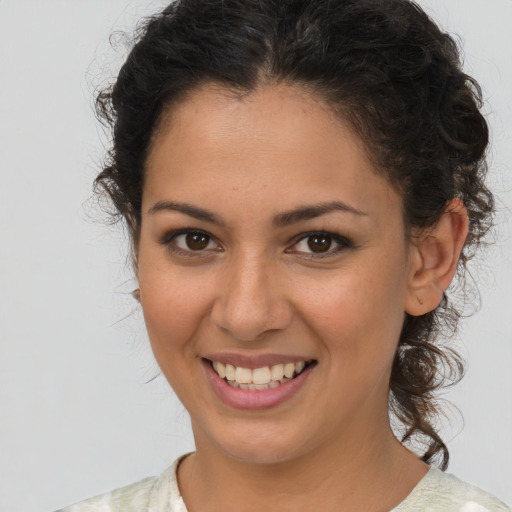 Joyful latino young-adult female with medium  brown hair and brown eyes