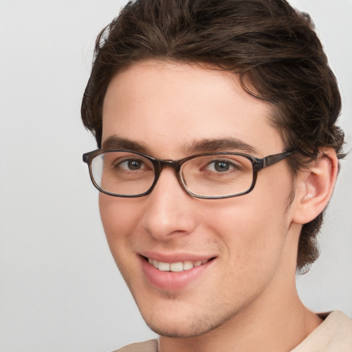 Joyful white young-adult male with medium  brown hair and green eyes