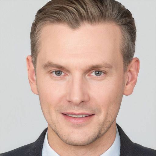 Joyful white adult male with short  brown hair and grey eyes