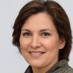 Joyful white adult female with medium  brown hair and brown eyes