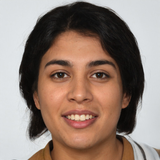 Joyful latino young-adult female with medium  brown hair and brown eyes