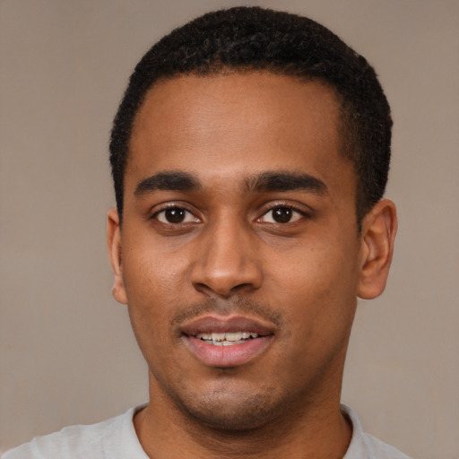 Joyful black young-adult male with short  black hair and brown eyes