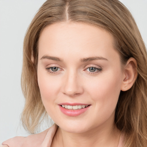 Joyful white young-adult female with long  brown hair and blue eyes