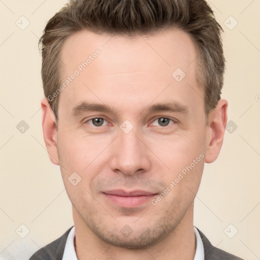 Joyful white young-adult male with short  brown hair and grey eyes