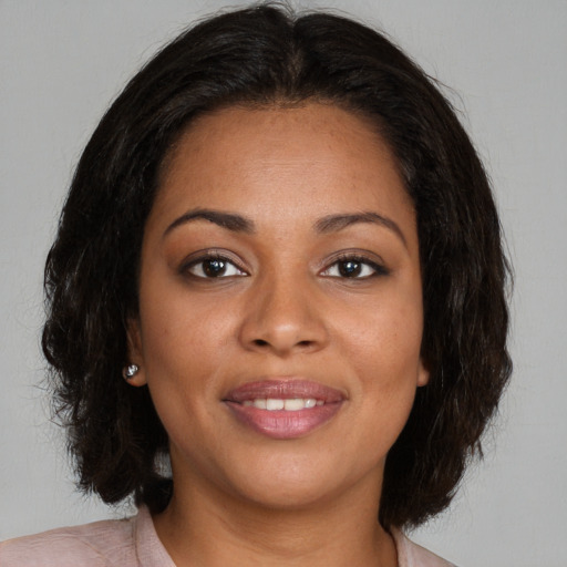 Joyful black young-adult female with medium  brown hair and brown eyes