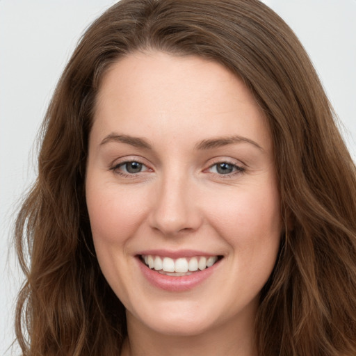 Joyful white young-adult female with long  brown hair and grey eyes