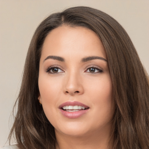 Joyful white young-adult female with long  brown hair and brown eyes