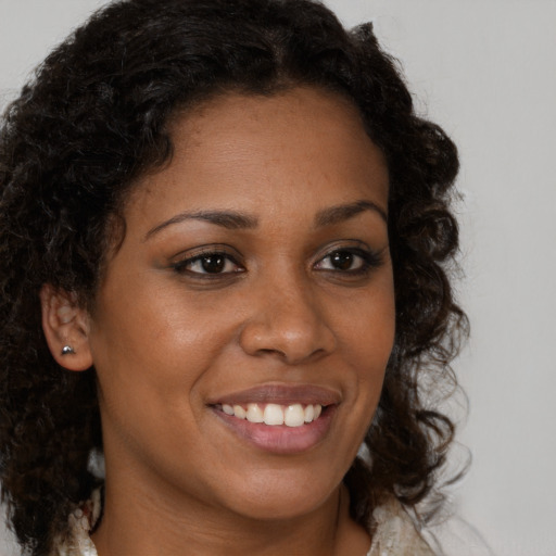 Joyful black young-adult female with medium  brown hair and brown eyes