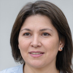 Joyful white adult female with medium  brown hair and grey eyes