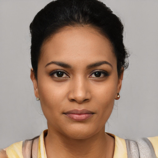 Joyful latino young-adult female with short  black hair and brown eyes