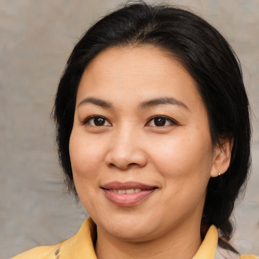 Joyful asian adult female with medium  brown hair and brown eyes