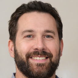 Joyful white adult male with short  brown hair and brown eyes