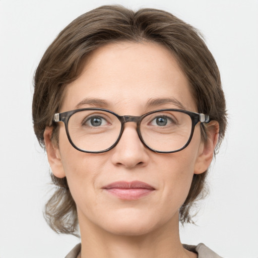 Joyful white adult female with medium  brown hair and grey eyes