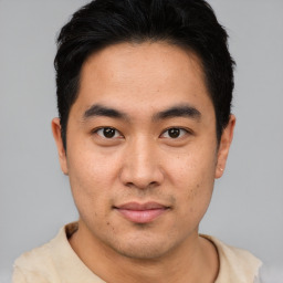 Joyful asian young-adult male with short  black hair and brown eyes