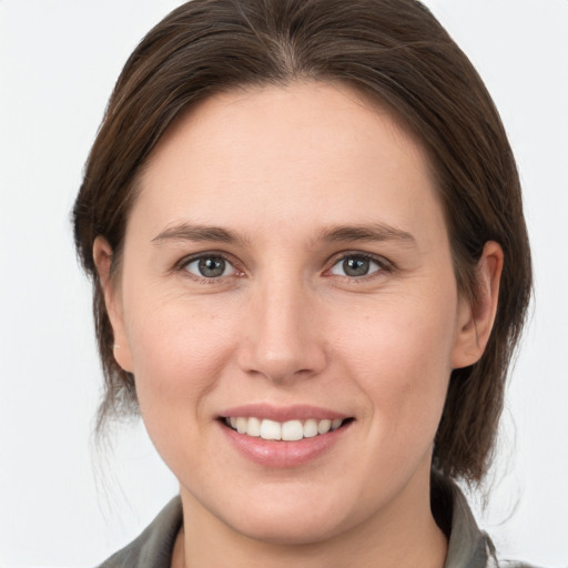 Joyful white young-adult female with medium  brown hair and grey eyes