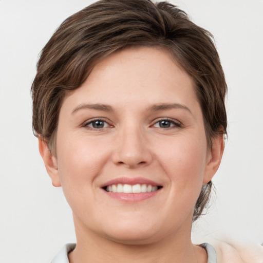 Joyful white young-adult female with short  brown hair and grey eyes