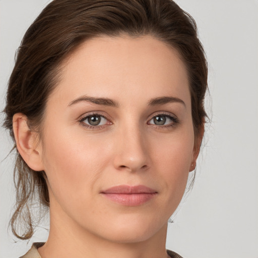 Joyful white young-adult female with medium  brown hair and grey eyes