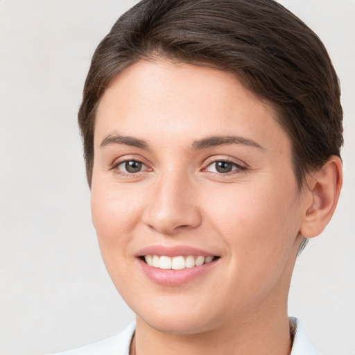 Joyful white young-adult female with short  brown hair and brown eyes