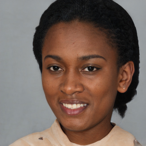 Joyful black young-adult female with short  black hair and brown eyes