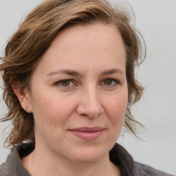 Joyful white adult female with medium  brown hair and grey eyes