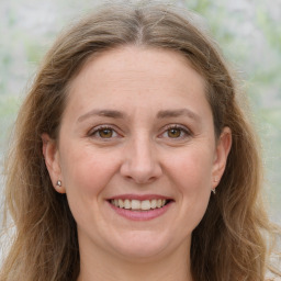 Joyful white adult female with long  brown hair and grey eyes