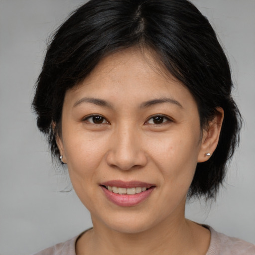 Joyful asian young-adult female with medium  brown hair and brown eyes