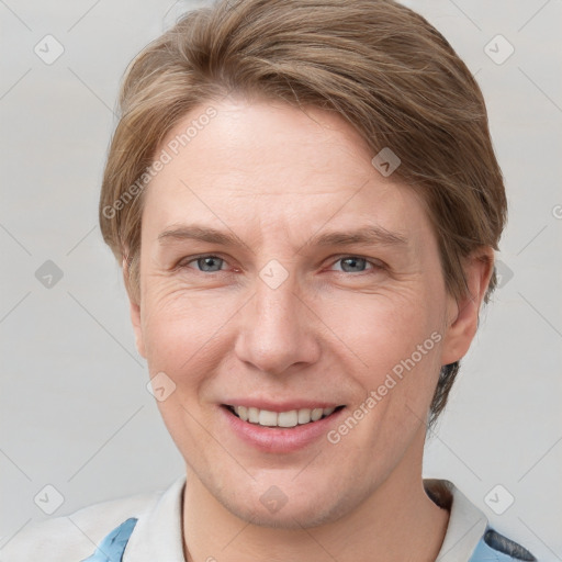 Joyful white adult female with short  brown hair and blue eyes