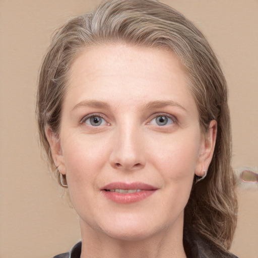 Joyful white adult female with medium  brown hair and grey eyes