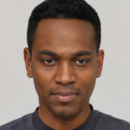 Joyful black young-adult male with short  black hair and brown eyes