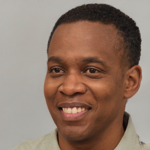 Joyful black young-adult male with short  brown hair and brown eyes