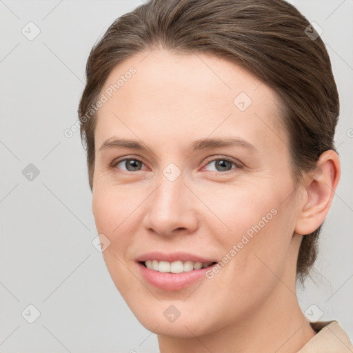 Joyful white young-adult female with short  brown hair and grey eyes