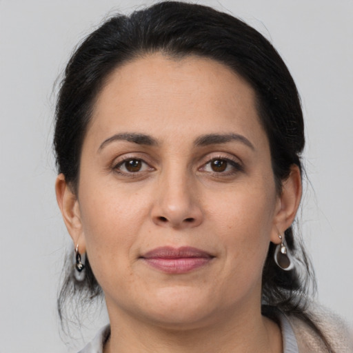 Joyful latino adult female with medium  brown hair and brown eyes