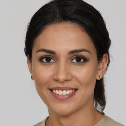 Joyful latino young-adult female with medium  brown hair and brown eyes