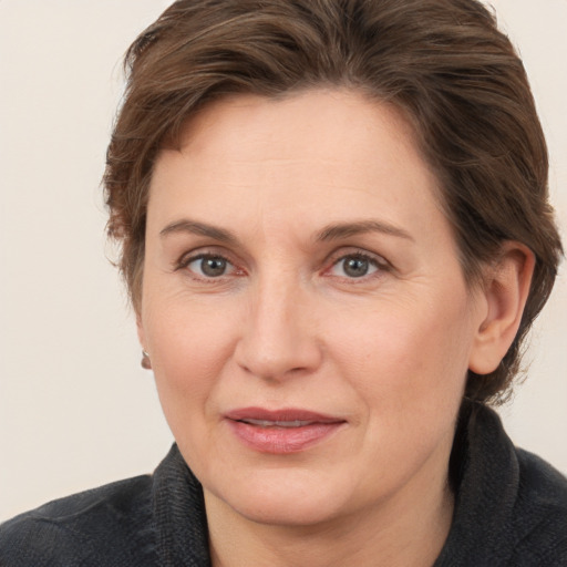 Joyful white adult female with medium  brown hair and grey eyes