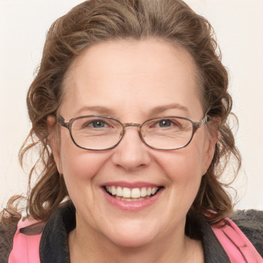 Joyful white adult female with medium  brown hair and blue eyes